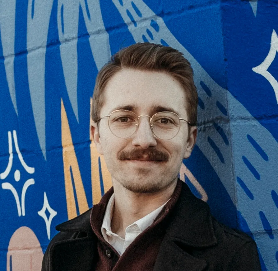 Keaton Conrad, founder of ByteCraft, in front of a painted mural